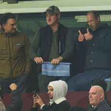 Prince William giving a thumbs up with friends at an Aston Villa match