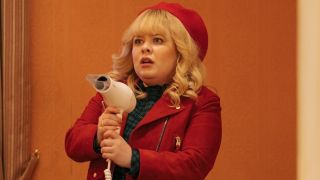 Nicola Coughlan as Joy holding a hair dryer in a red outfit in Doctor Who