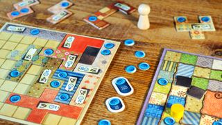 Patchwork boards, tiles, and tokens laid out on a wooden table