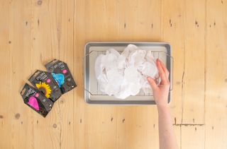 A damp t-shirt in a tray on a table.