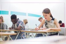 A group of students sat a t desks while taking an exam