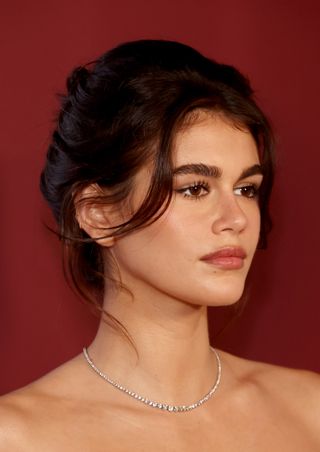 Kaia Gerber on a red carpet wearing a diamond necklace