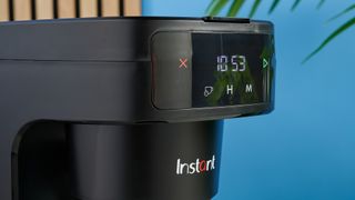 A black Instant Infusion Brew 12-Cup drip coffee maker with a removable water reservoir, glass carafe and reusable coffee filter