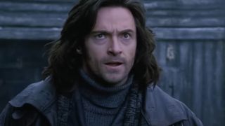 Hugh Jackman stands outside on a dreary day with a look of concern in Van Helsing.