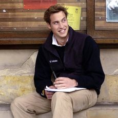 Prince William sits on a stone bench in St Salvator's Quad at St Andrews University where he is a student. 