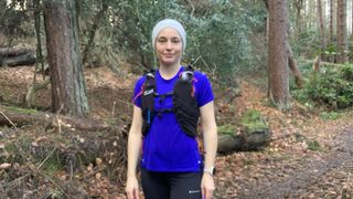 Trail runner in blue shirt wearing the Camelbak Apex Pro running vest