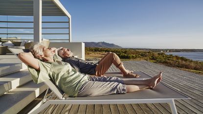 A retired couple sit on the terrace of their second home.