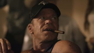 Screenshot of Taylor Sheridan's Travis smoking a cigar at poker table in Yellowstone Season 5