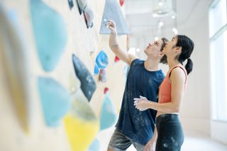 couple goes rock climbing on a rock climbing wall