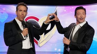 Ryan Reynolds and Hugh Jackman making a heart with their hands in front of Deadpool & Wolverine heart logo while at Jimmy Kimmel Live! on July 24, 2024