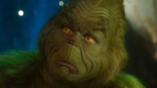 Jim Carrey's Grinch sits in his cave wearing a look of curiosity in Dr Seuss' How The Grinch Stole Christmas.