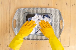 Someone in rubber gloves filling a deep dish with the blue dye