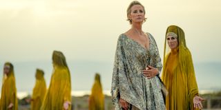 Janet McTeer as Hera in a flowing dress on a mountainscape.