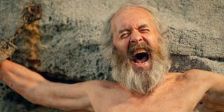 Stephen Dillane as Prometheus screaming in pain and chained to a cliff.