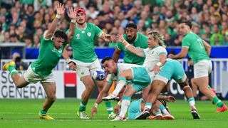 An Ireland rugby player in green (left) runs to block a kick from Faf Dev Klerk during South Africa vs Ireland.