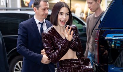 Lily Collins in a burgundy reptile print set 