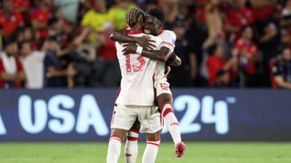 Derek Cornelius and Alphonso Davies hug in celebration as Canada qualify from the groups at the Copa America 2024.