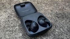 Sennheiser Momentum Sport earbuds on grey table background