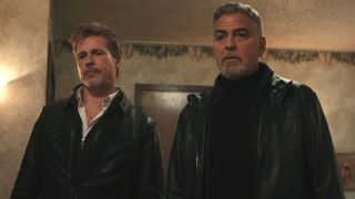 Brad Pitt and George Clooney standing together with looks of disbelief in Wolfs.