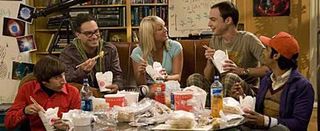 From left, characters Howard, Leonard, Penny, Sheldon and Raj from the CBS show "The Big Bang Theory." sit on a sofa and the floor eating food.