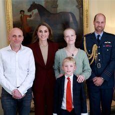 Kate Middleton posing with teenage photographer Liz, her brother, father and Prince William standing in front of a painting of a horse