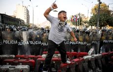 A protester shouts at riot police in a demonstration against rising crime and extortion in Lima