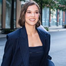 Hailee Steinfeld wears a navy blue pinstripe blazer and matching top 