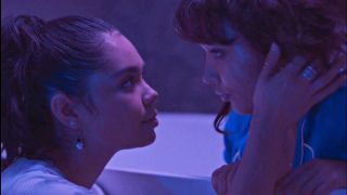 Auli'i Cravalho and Rowan Blanchard leaning in for a kiss with purple lighting in 2022's Crush