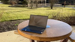 A Lenovo IdeaPad Slim 3i on a table outside in a park