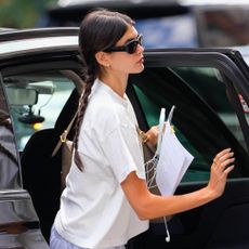 Kaia Gerber exits a car in manhattan wearing a white t shirt gray sweatpants it sneakers and a stack of classic accessories