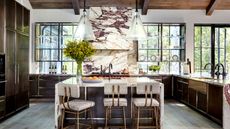 kitchen with marble hood and counters and dark cabinets