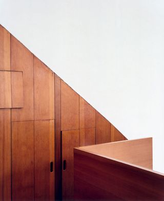 Two wooden, built-in closets in a diagonal shape.