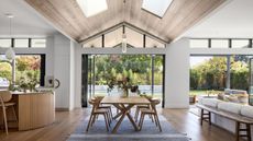 kitchen with wooden floor and dining table full height window