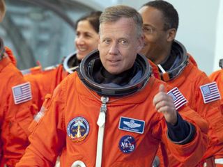 During a simulated launch countdown, the STS-133 crew walks out of the Operations and Checkout Building to the waiting Astrovan at NASA's Kennedy Space Center in Florida. Commander Steve Lindsey gives a thumbs up to Kennedy employees who are cheering for the crew.