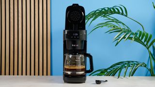 A black Instant Infusion Brew 12-Cup drip coffee maker with a removable water reservoir, glass carafe and reusable coffee filter