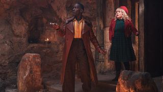 The fifteenth Doctor (Ncuti Gatwa) and a nervous Joy Almondo (Nicola Coughlan) entering an ancient cave in the Doctor Who 2024 Christmas Special.