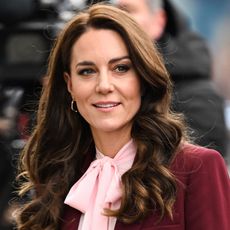 Kate Middleton wears a burgundy blazer and a pink pussy-bow blouse