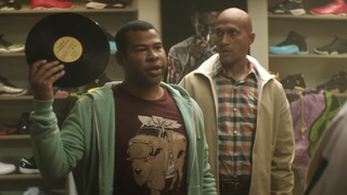 Clarence looking at Rell holding a vinyl record in Keanu