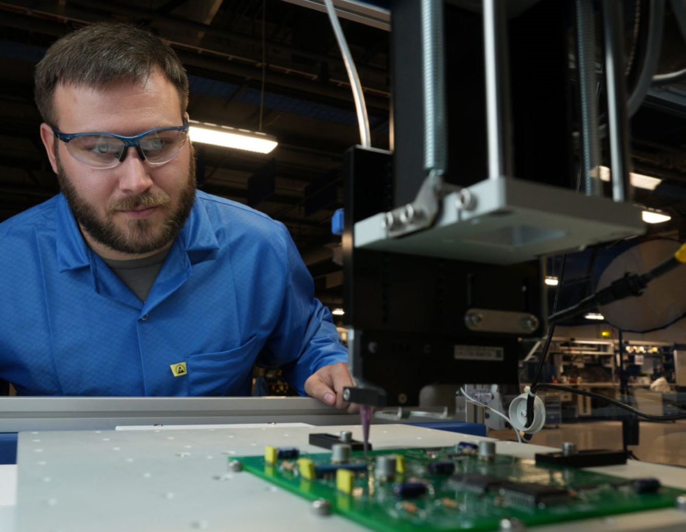 man working at manufacturing equipment used for fluid application processes