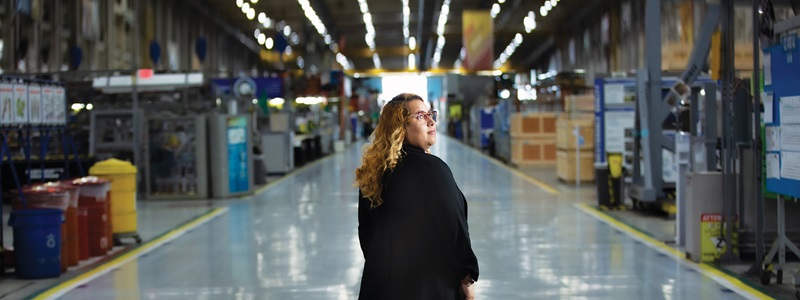 female in factory smiling.