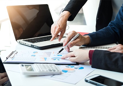 Individuals working together and pointing at various pie charts