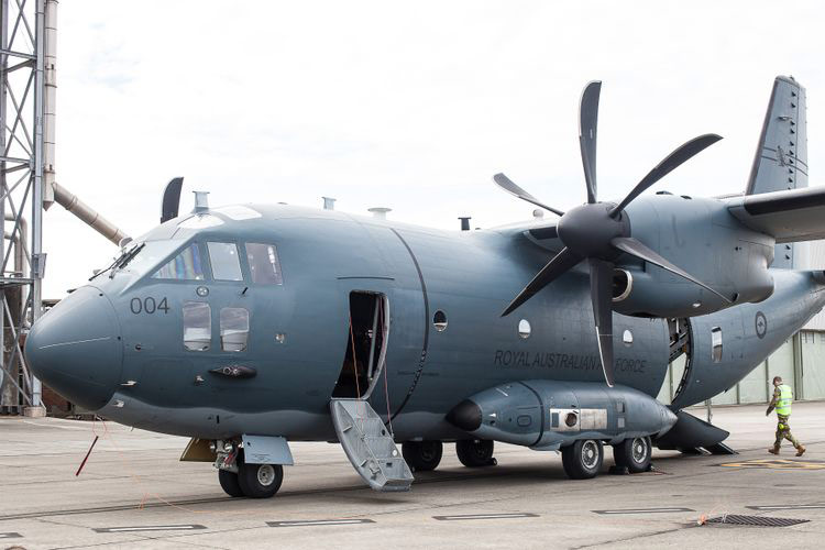 A large gray aircraft sits with its door open