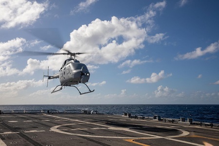 A helicopter hovers above a landing pad