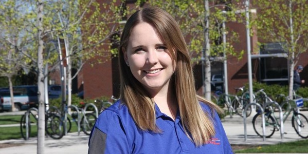 Female standing outside a building and in front of a bike rack