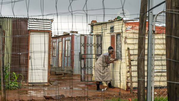 Moradora do assentamento de Vlakfontein, nos arredores de Joanesburgo, África do Sul, fecha sua janela durante uma tempestade 
 - Sputnik Brasil