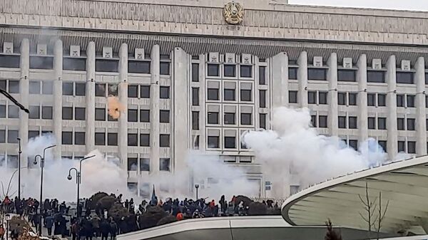 Manifestantes perto de prédio administrativo durante protestos contra a subida do preço de gás de petróleo liquefeito pelas autoridades cazaques, em Almaty, Cazaquistão, 5 de janeiro de 2022 - Sputnik Brasil