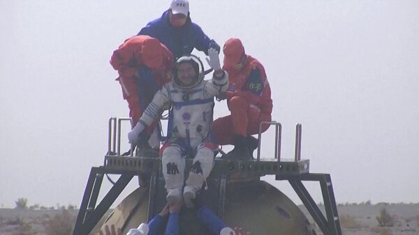 Captura de tela feita a partir de um vídeo divulgado pela emissora estatal chinesa CCTV mostra o astronauta chinês Zhai Zhigang acenando no topo da cápsula da espaçonave Shenzhou-13 após pousar na Mongólia Interior, China, 16 de abril de 2022 - Sputnik Brasil