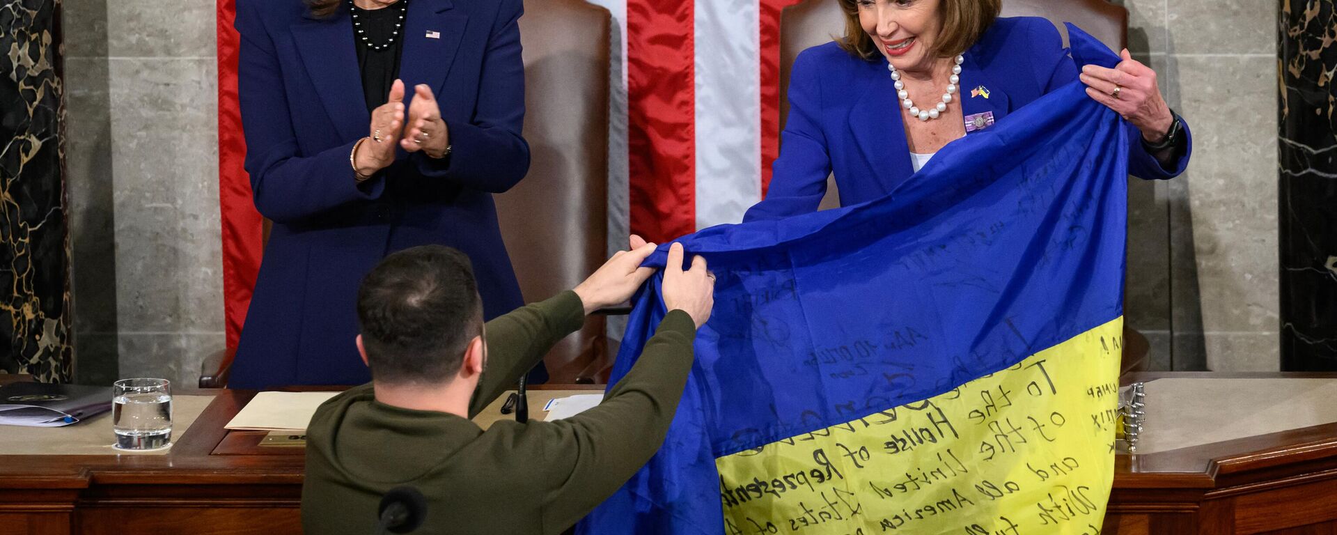 Vladimir Zelensky, presidente da Ucrânia, segura bandeira nacional do país junto de Nancy Pelosi, presidente da Câmara dos Representantes dos EUA, e Kamala Harris, vice-presidente dos EUA, durante discurso do primeiro no Congresso do país norte-americano em Washington, EUA, 21 de dezembro de 2022 - Sputnik Brasil, 1920, 16.01.2023