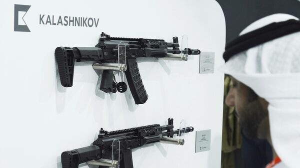 Um homem emiradense passa por fuzis Kalashnikov em uma tenda para fabricantes de armas russos na Exposição e Conferência Internacional de Defesa em Abu Dhabi, Emirados Árabes Unidos, na segunda-feira, 20 de fevereiro de 2023. Fora da feira bienal de armas de Abu Dhabi, em uma grande tenda, a Rússia apresentou armas para venda desde fuzis de assalto Kalashnikov até sistemas de mísseis, apesar das sanções do Ocidente pelo conflito na Ucrânia. - Sputnik Brasil