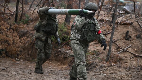 Soldados do Regimento de Fuzis Motorizados de Guardas do Distrito Militar Central da Rússia carregam projétil para o lançador múltiplo de foguetes BM-21 Grad na direçao de Krasny Liman, durante a operação militar especial, foto publicada em 17 de novembro de 2023 - Sputnik Brasil